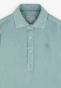 Polo bleu clair à manches courtes en tissu texturé, avec une patte de boutonnage et un petit logo brodé sur la poitrine.