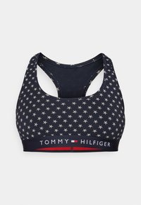 Marine sportbh met witte sterrenpatronen, racerback ontwerp, en een contrasterende band met de tekst "TOMMY HILFIGER" in rood en wit.