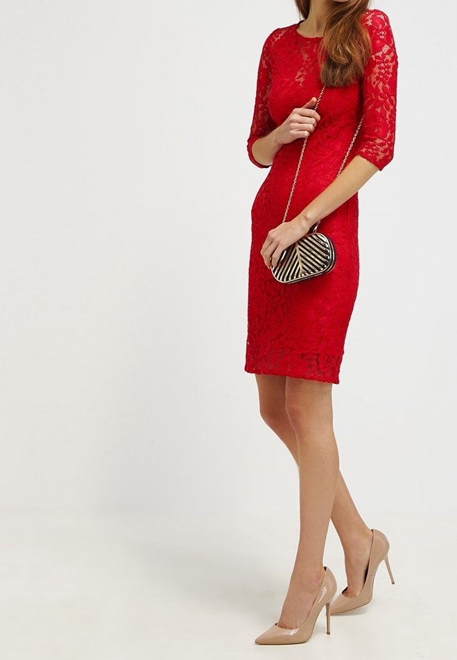 Vestido de encaje rojo con mangas tres cuartos, silueta ajustada y dobladillo a la altura de la rodilla. Combinado con un clutch negro y dorado y tacones nude.