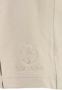Beige Shorts mit gesticktem Logo "KEY LARGO" und glatter Textur. Das Design umfasst Nahtdetails entlang dem Saum.