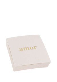 Kvadratisk krämfärgad låda med rundade kanter, med ordet "amor" präglat i tjocka guldiga bokstäver på ovansidan.