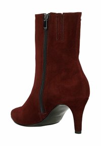 Burgundské semišové kotníkové boty s zaoblenou špičkou, bočním zipem a štíhlým podpatkem. Hladký povrch s matným finišem.