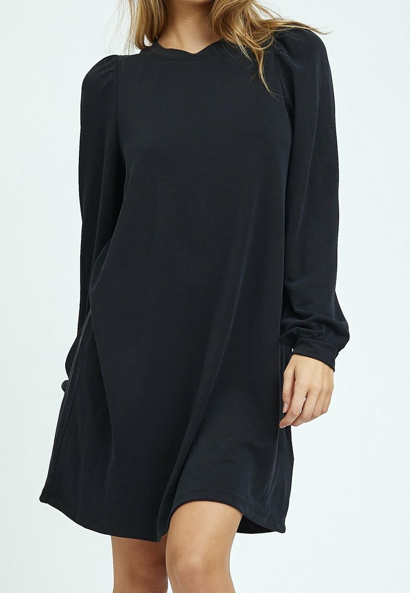 Robe noire à manches longues avec une coupe décontractée, un col rond et des coutures froncées aux épaules ; tissu lisse avec peu de détails.