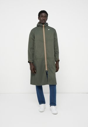 Olijfgroen regenjas met een capuchon, voorzien van een centrale rits en geel-oranje strepen. Slim fit met lange mouwen en sluitingen bij de manchetten.