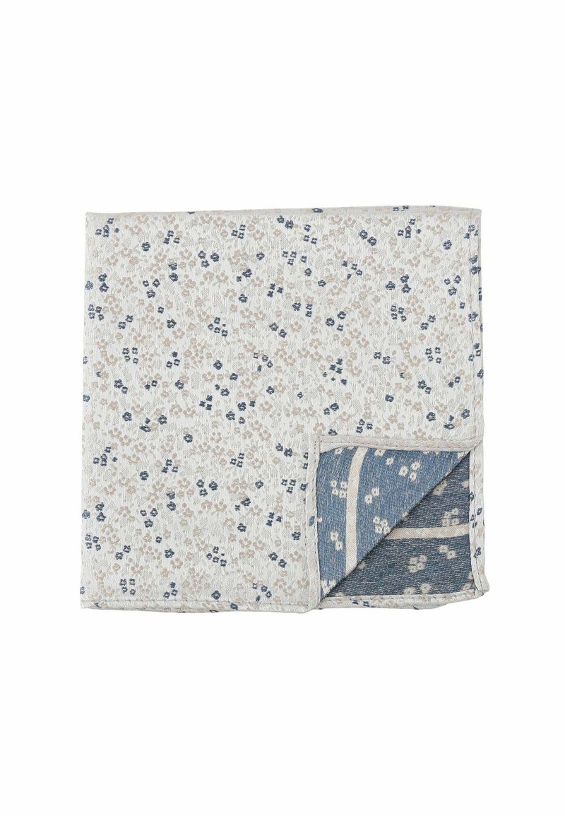 Floral-patterned quilted blanket with a white background and beige and navy blue accents. Soft texture with a reversible design in blue.