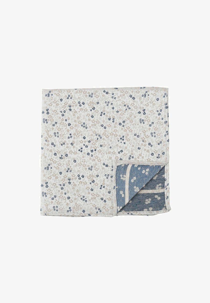 Floral-patterned quilted blanket with a white background and beige and navy blue accents. Soft texture with a reversible design in blue.
