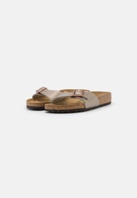 Lys beige sandaler med doble remmer og et spenne detalj. Har en korkfotseng og strukturerte gummisåler, som gir komfortabel støtte.