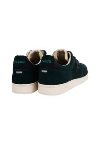 Un paio di sneaker in costina verde scuro con suole beige, con "FAGUO" ricamato sui talloni e il logo "F" nero sui lati, mostrato da un angolo posteriore.