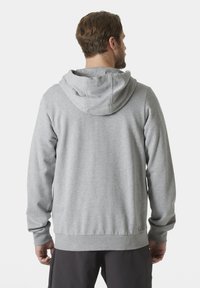 Sudadera gris hecha de una tela suave, con capucha ajustable y puños acanalados. Diseño simple sin patrones o logotipos visibles.