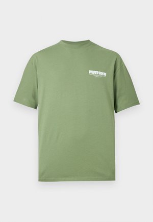 Camiseta verde de manga corta con cuello redondo y texto blanco "MATCHA" junto con caracteres japoneses en la parte superior izquierda del pecho.