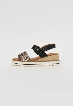 Black and leopard print sandal with a wide strap and adjustable buckle, featuring a wedge jute sole and rubber outsole with scalloped edge.