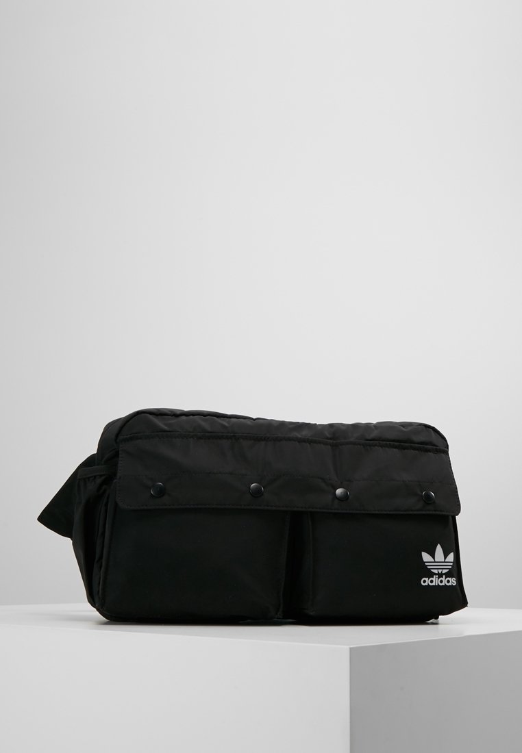 Svart Adidas midjeväska med framklaff och tryckknappar, två framfickor och vitt Adidas-logotyp på nedersta högra fickan.