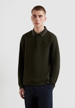 Donkergroene polo met lange mouwen en een kraag, met witte accentstrepen en een klein oranje logo op de linkerborst. Zacht materiaal.