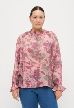 Floral blouse in pink and green tones, featuring a gathered neckline and ruffled cuffs. Light, textured fabric with loose fit.