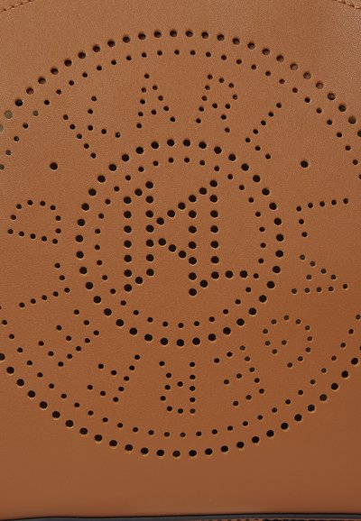 Sac à main en cuir marron avec des motifs circulaires perforés, mettant en avant un design de logo central. Texture lisse avec des accessoires en métal robustes.