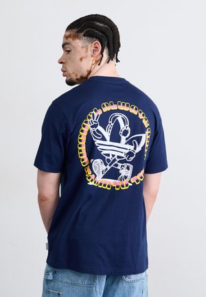 Marineblå bomulds t-shirt med et stort grafisk design på ryggen, der viser en tegnefilmfigur, hovedtelefoner og tekst i gul og pink.