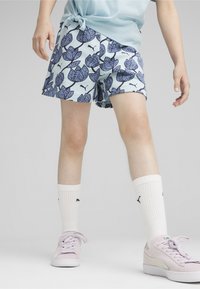 Pantalones cortos azul claros con un patrón floral en azul oscuro, combinados con calcetines blancos de caña corta y zapatillas rosas claras.