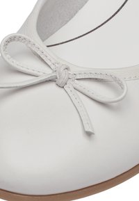 Ballet flat bianco in pelle con punta rotonda, caratterizzato da un piccolo fiocco decorativo e suola beige. Texture liscia e design semplice.