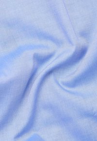 Tessuto intrecciato di colore azzurro chiaro con una superficie liscia, caratterizzato da fini motivi diagonali e una leggera lucentezza, drappeggiato per mostrare morbidezza e flessibilità.