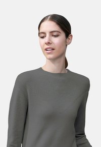 Pull en tricot gris avec un motif texturé sur le plastron, col rond côtelé et manches longues. Tissu doux de poids moyen.