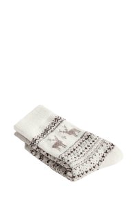 Złożone białe i beżowe wełniane skarpetki z wzorami reniferów i płatków śniegu w kolorach brązowym i ciemnoczerwonym.