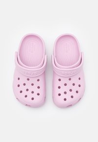 Pink Crocs clogs made of lightweight material, featuring ventilation holes, a rounded shape, and adjustable back strap for secure fit.