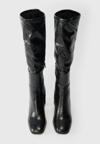 Juodos iki kelių ilgio batai, pagaminti iš lygaus, blizgaus odos, su kvadratiniu pirštu ir priderinta ašimi. Yra subtili užtrauktuko detalė šonuose.