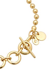 Guldfärgad halsband med rundade pärlor, sammanlänkade ringar och en lås med två små runda hängen.