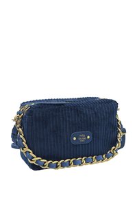 Sac à épaule en velours côtelé bleu marine avec une bandoulière en chaîne dorée, fermeture éclair, et une plaque de devant avec "mila louise PARIS" embossée. Surface texturée.