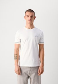 T-shirt bianco in cotone a maniche corte, con un logo blu navy sul lato sinistro del petto e dettagli a righe sulle maniche.