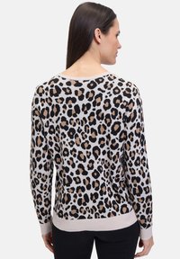 Leopardenmuster-Pullover aus weichem Strickstoff, mit schwarzen und braunen Flecken auf einem hellen Grund, sowie einem gerippten Saum und Bündchen.