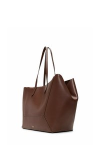 Brown large leather tote bag with dual handles and geometric side panels, featuring a small gold logo on the front.
