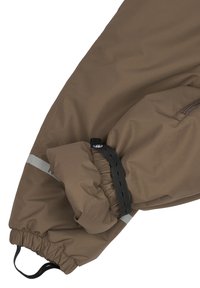 Bruine waterdichte jas met elastische manchetten, zwarte verstelbare band en reflecterende grijze accenten. Gladde stof met een matte afwerking.