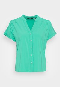Camisa verde de manga corta con cuello, frente abotonado y textura suave. Cuenta con mangas enrolladas y un ajuste relajado.