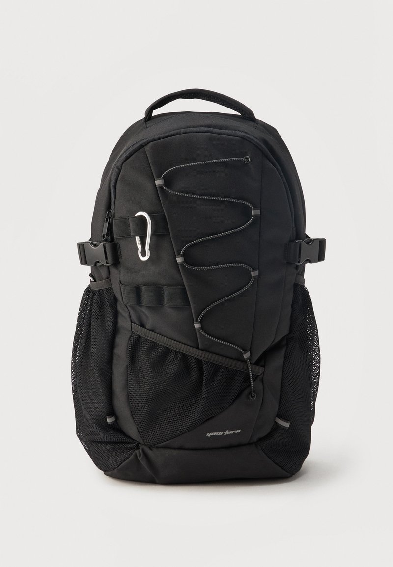 Sac à dos noir avec cordon élastique à l'avant, poches latérales en mesh, bretelles réglables et mousqueton argenté sur fond uni.