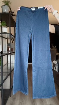 Pantaloni in denim a palazzo di colore blu scuro, con una texture liscia, vita alta e design semplice. L'etichetta riporta "ONLY."
