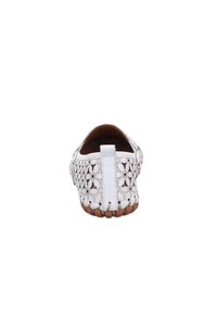 Weiße Leder-Slipper mit aufwendigen Ausschnittmustern, einer strukturierten braunen Sohle und einer kleinen Fersenschlaufe für ein einfaches An- und Ausziehen.