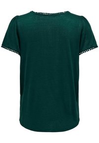 Blouse courte à manches courtes vert foncé avec encolure ronde et petit galon à pompons sur les manches et les bords du col.