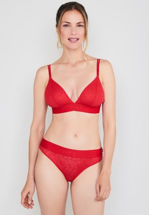Red lingerie set featuring a wire-free bralette with a wave pattern and adjustable straps, paired with matching sheer bikini panties.