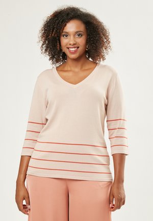 Helles beige Strickoberteil mit V-Ausschnitt, dreiviertel Ärmeln und roten horizontalen Streifen über dem Oberkörper. Weiche Textur, lockere Passform.