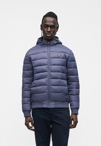 Navy padded jacket with a zip front and hood. Features a small gold logo on the left chest and ribbed cuffs and hem. Smooth texture.