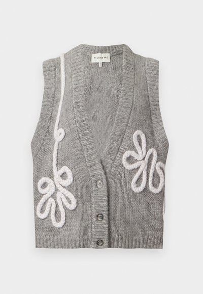 Cardigan sans manches gris tricoté avec un col en V profond, trois boutons et une broderie florale blanche en boucles sur les côtés avant.