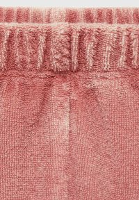 Mjuk rosa handduk med en strukturerad yta. Har en r gathered elastisk midja upptill. Horisontella ränder syns över hela materialet.
