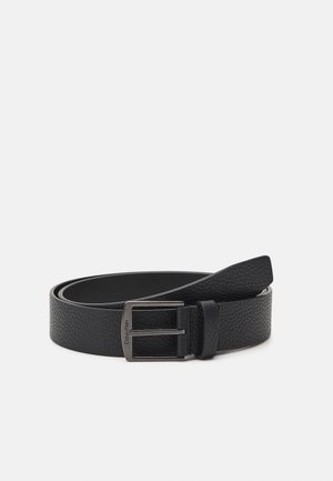 Mustmustööst valmistatud must nahkse vööd, millel on tekstuuriga pind ning metallist pandla. Kujundus sisaldab klassikalist kuju ja brändi logo pandlal.