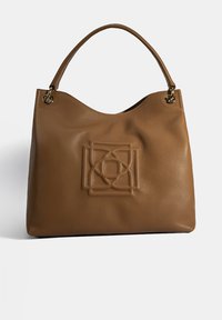 Bruine leren handtas met een gestructureerde afwerking, een gebogen bovenkant en een opvallend reliëf logoontwerp aan de voorkant. Kenmerkt gouden hardware accenten.