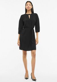 Czarna sukienka z okrągłym dekoltem, wycięciem z przodu, rękawami do łokcia i wiązanym paskiem w talii. Gładka tkanina o luźnym kroju.