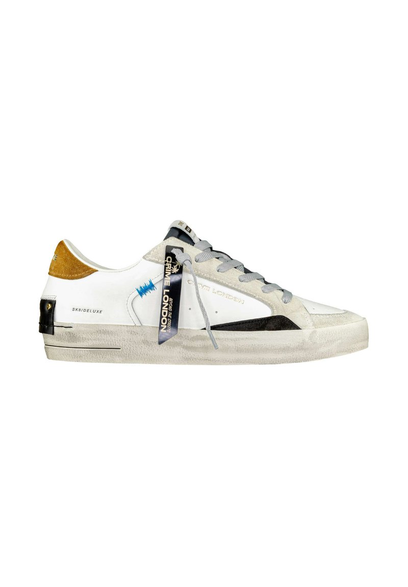 Sneaker in pelle bianca con lacci grigi, dettagli neri e un inserto in suede marrone sul tallone. Presenta una suola in gomma e un'etichetta con il marchio.