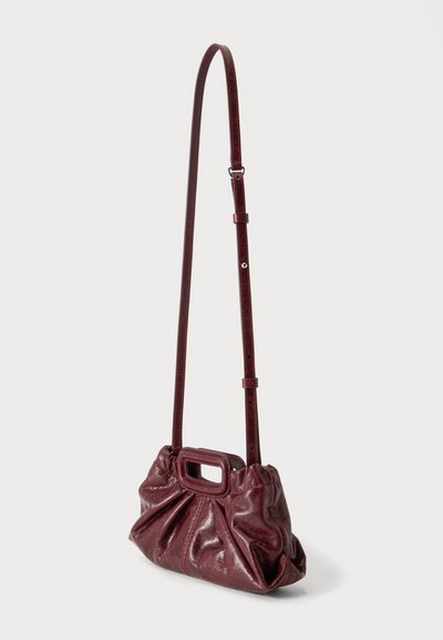 Sac à bandoulière en cuir rouge foncé avec texture froncée et poignée rectangulaire découpée, avec une longue sangle réglable.
