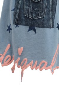 Niebieska tkanina z detalem kieszeni z dżinsu, różowym napisem "desigual" i granatowymi wzorami gwiazdek, z postrzępionym dołem i miękką teksturą.