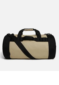 Borsa a mano in tessuto beige e nero, di forma cilindrica, con manici neri e tracolla regolabile, dotata di una tasca laterale in rete.